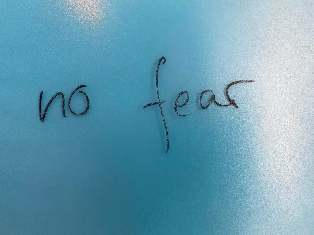 no fear written on a blue wall 