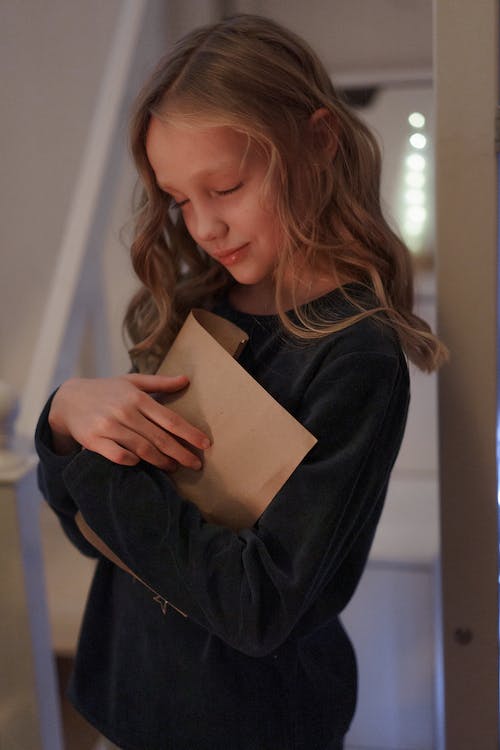 A girl holding a card - maybe a condolence messages card? 